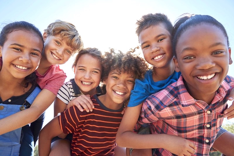 a diverse group of kids laughing and smiling