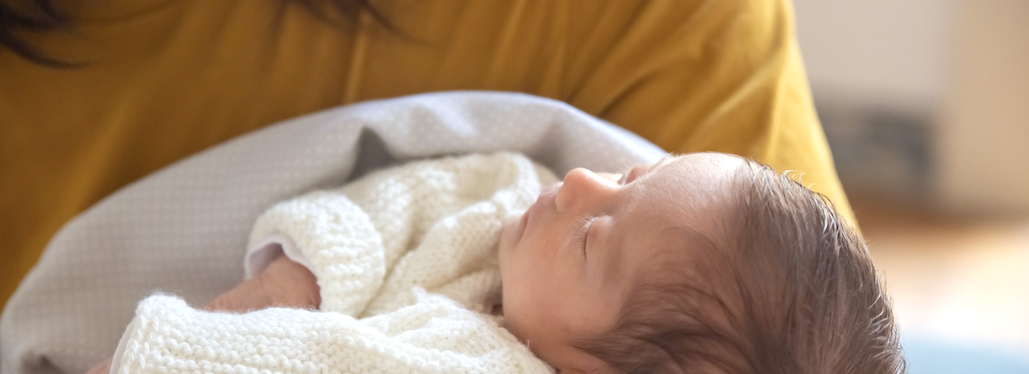 A baby sleeping in a person's arms